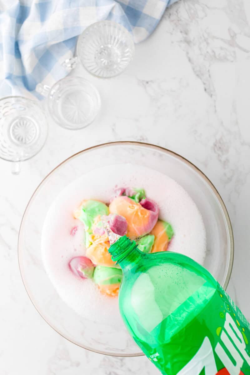 pouring the soda into the serving bowl with the sherbet.