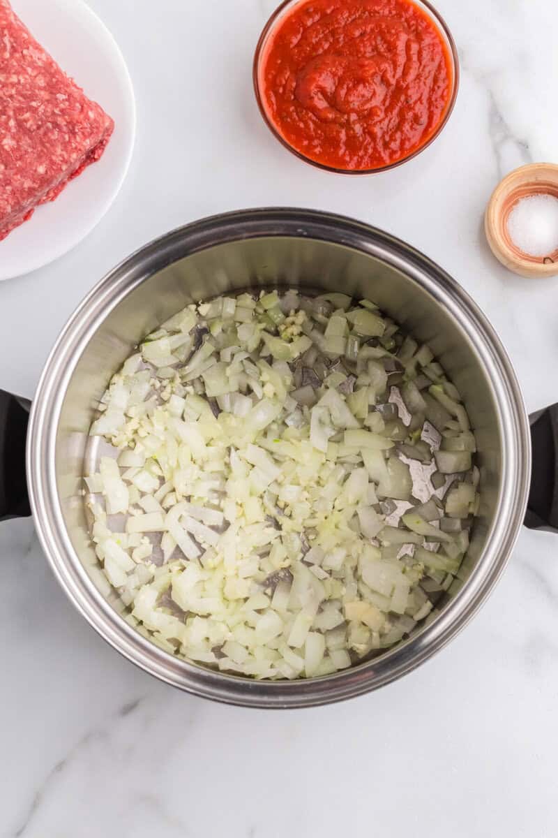 cooking the onion and garlic in the bottom of the soup pot.
