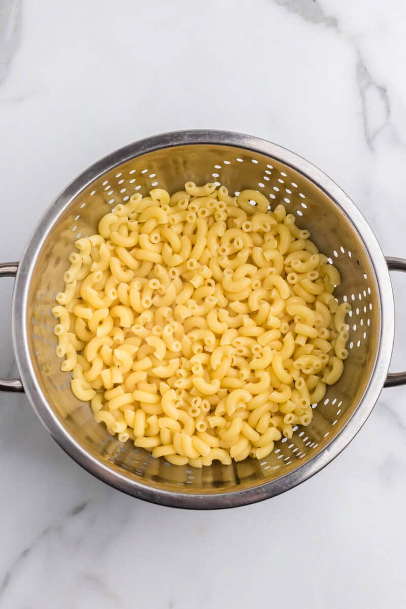 cooked macaroni noodles in a colander.