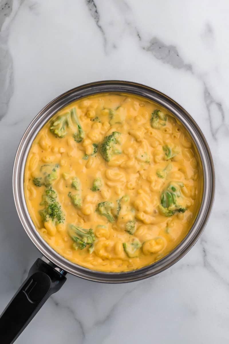 adding the broccoli to the mac and cheese.