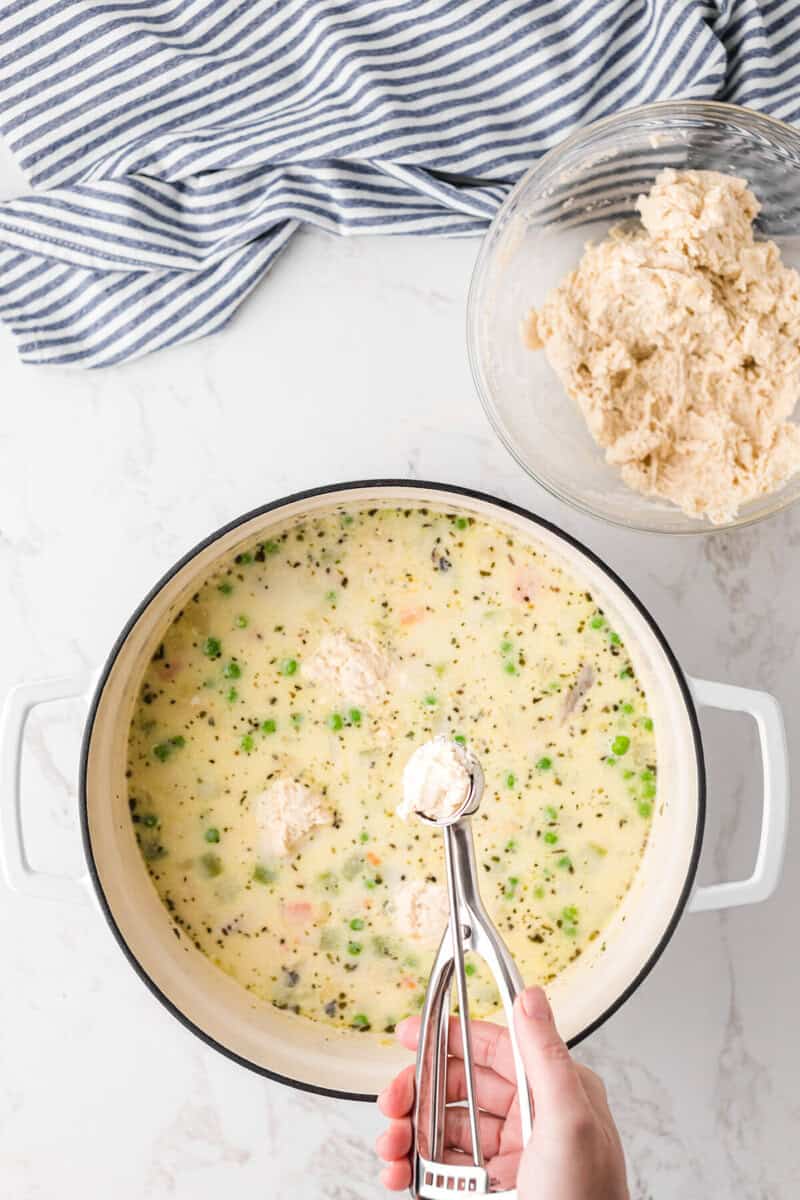dropping the dumplings into the chicken soup.
