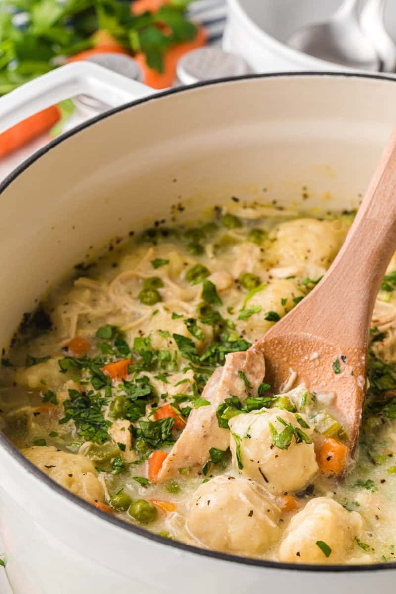 closeup of the Chicken Dumpling Soup being served with a wooden ladle.