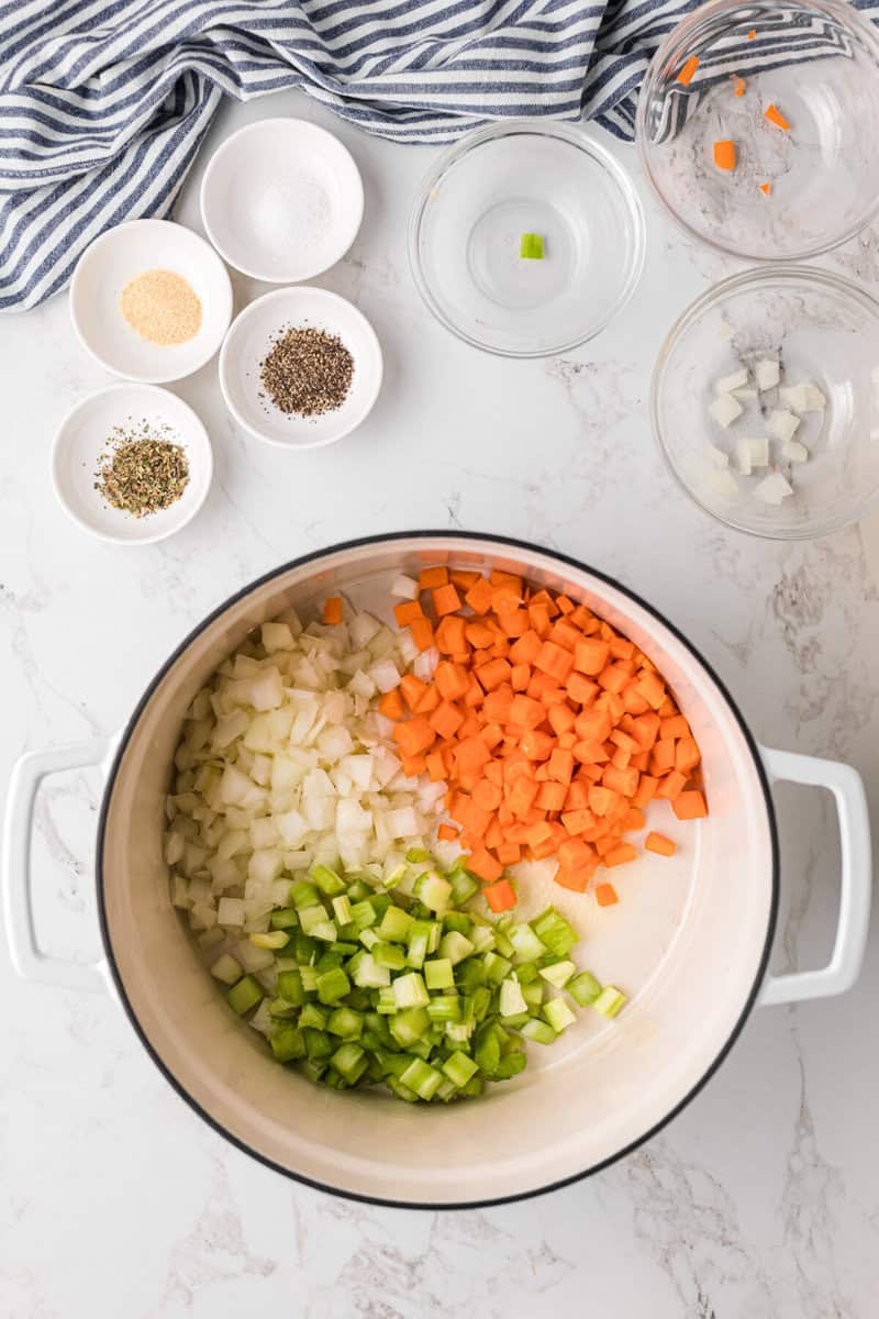 adding the onions, carrots and celery to the bottom of the stock pot.
