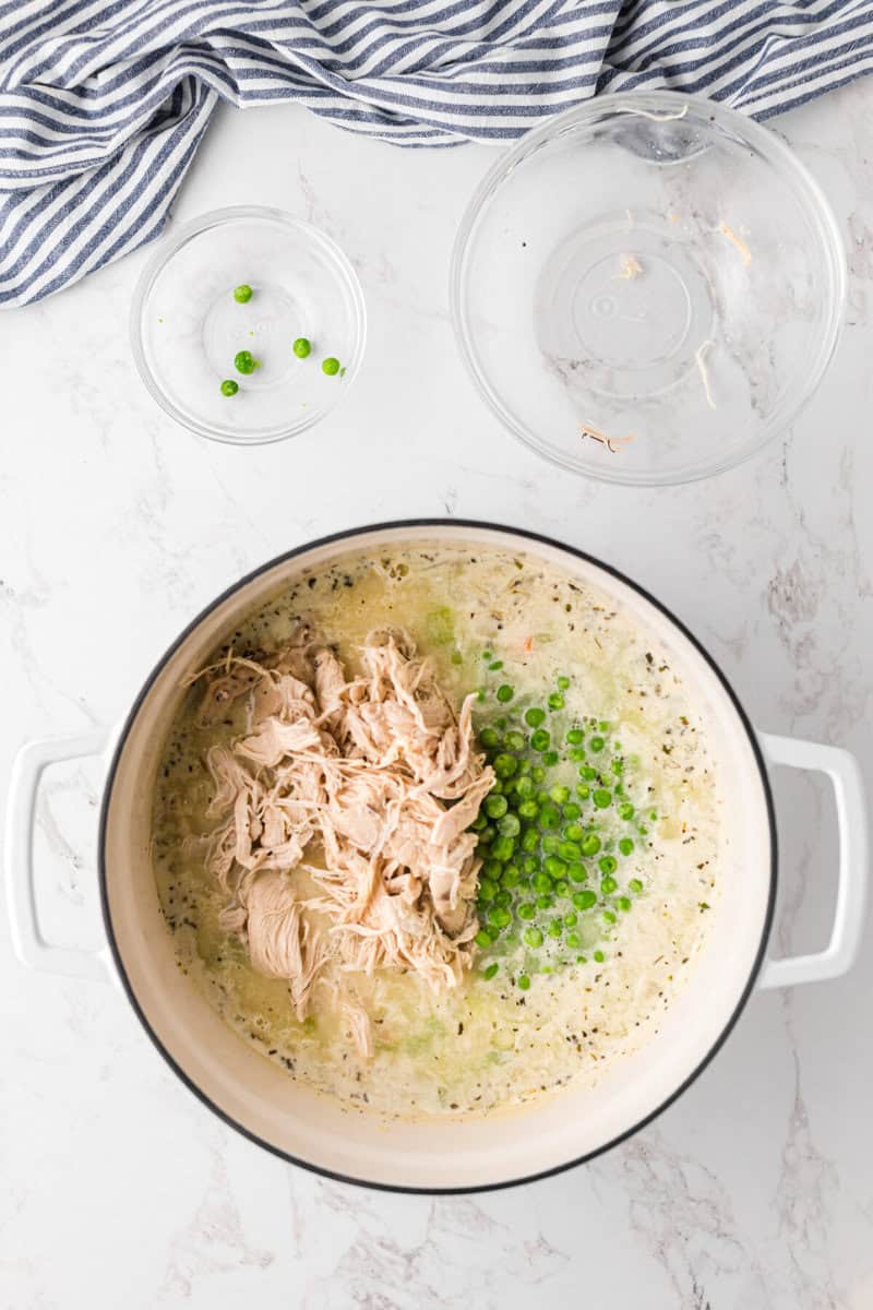 adding the chicken and the peas to the soup pot.