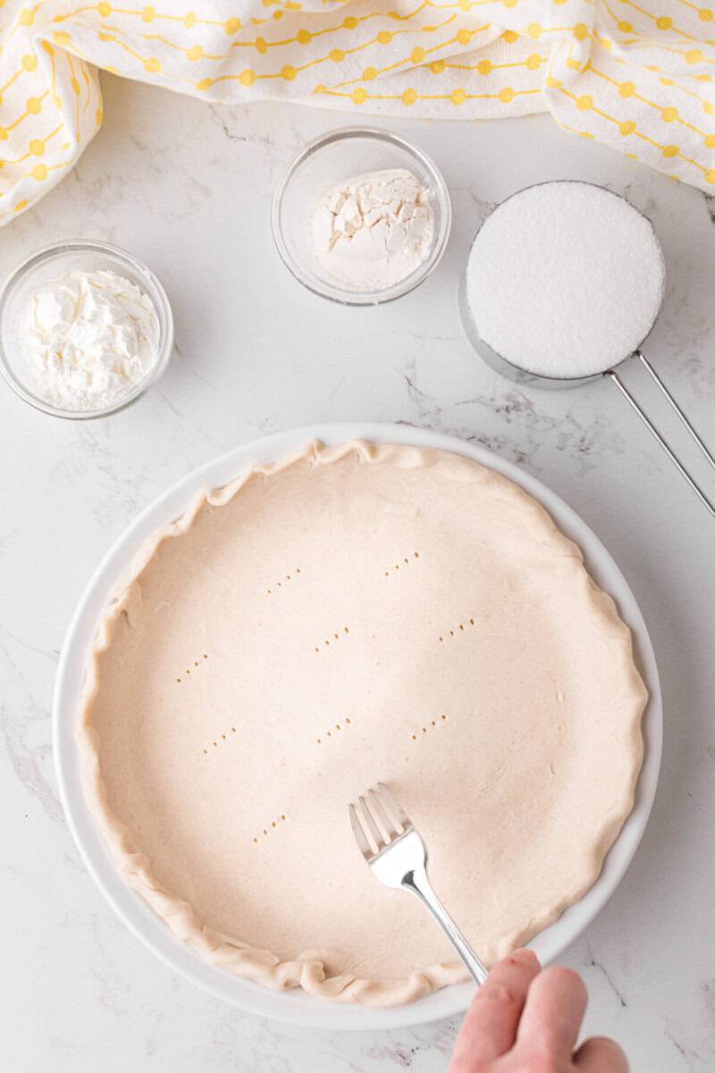 poking holes into the pie crust with a fork.
