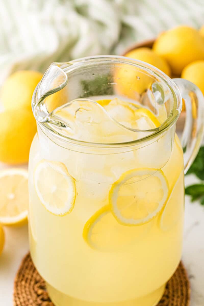 pitcher of the Homemade Lemonade with lemon slices in it.