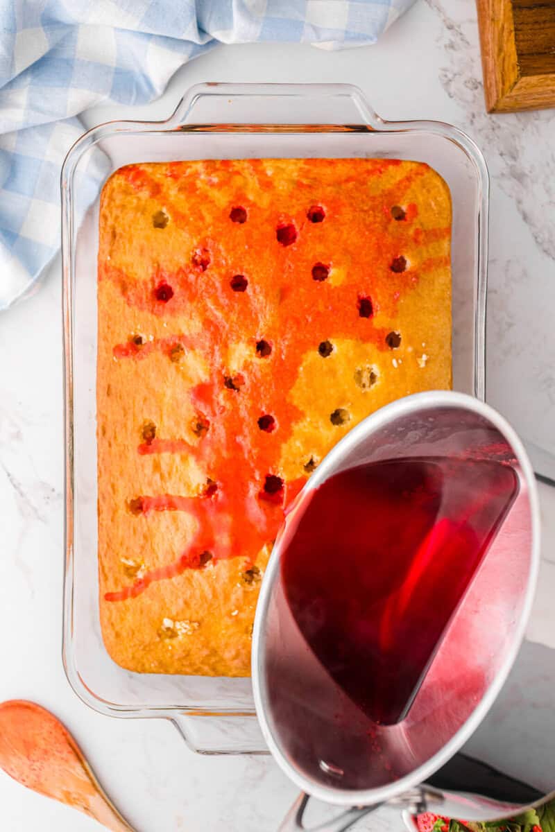 pouring the Jell-O onto the cake and into the holes in the cake.