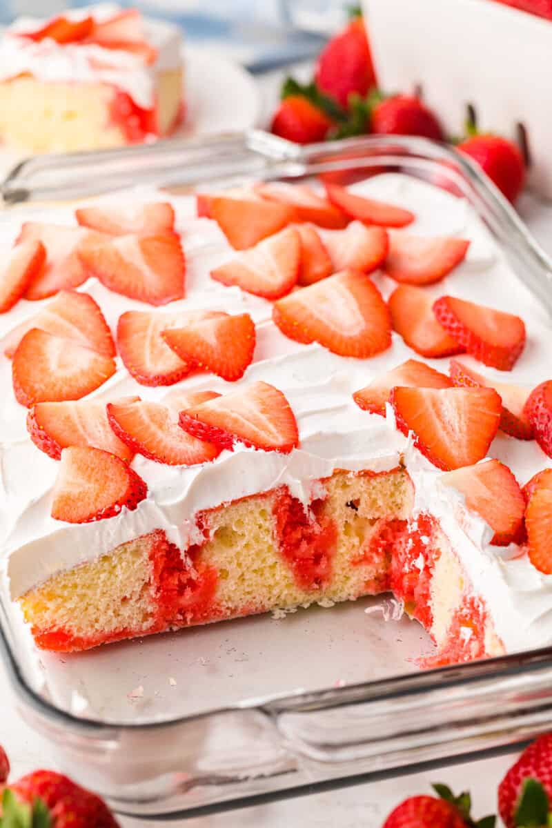 closeup of the Strawberry Poke Cake with a slice taken out of it.