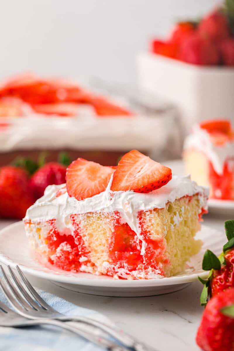 slice of the Strawberry Poke Cake on a white plate.