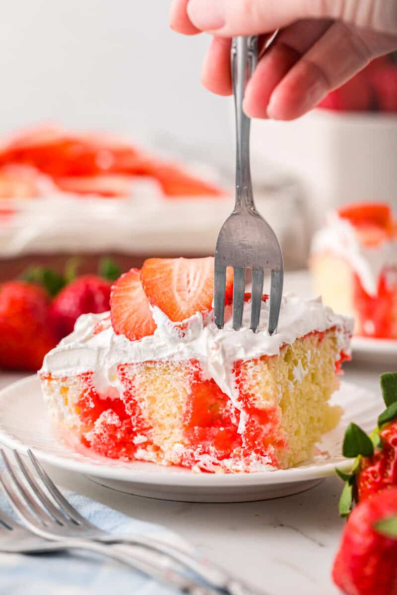 Slice of the Strawberry Poke Cake on a white plate.
