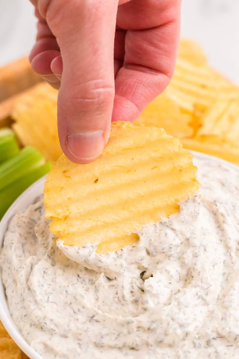 dipping a potato chip into the Dill Dip.