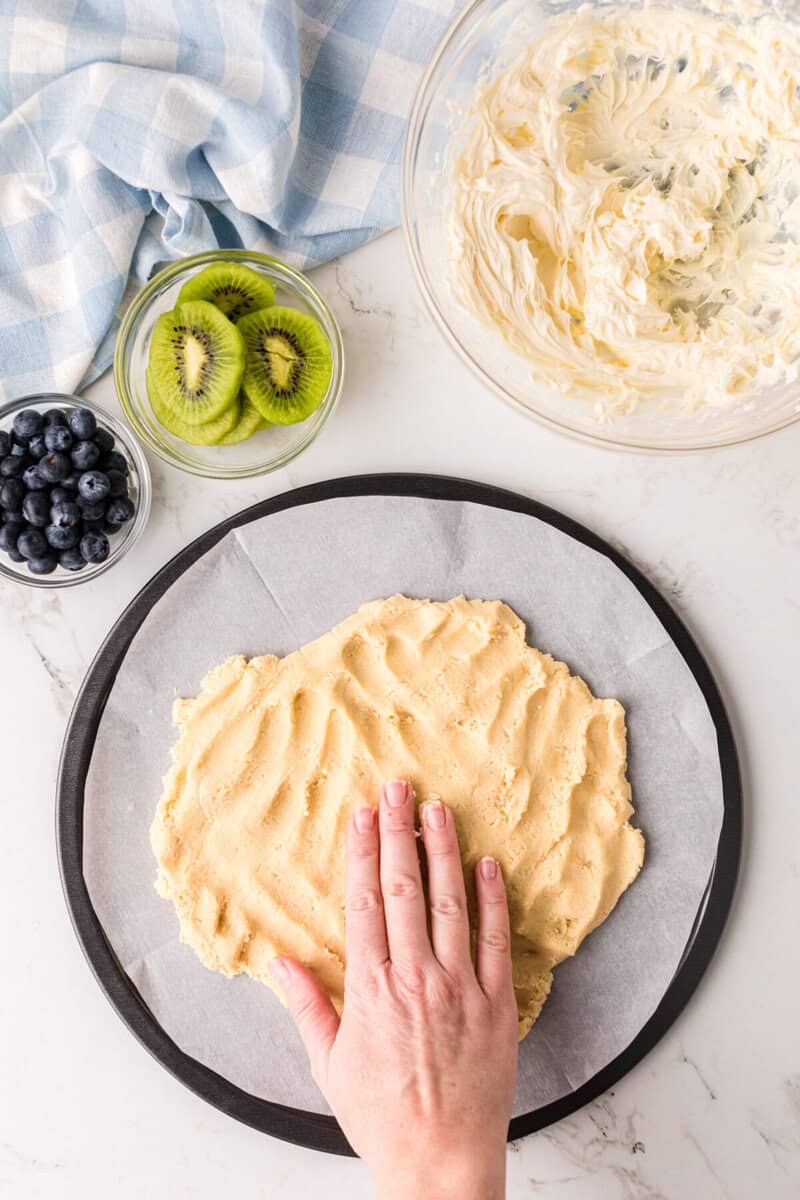pressing the crust on to a baking pan.