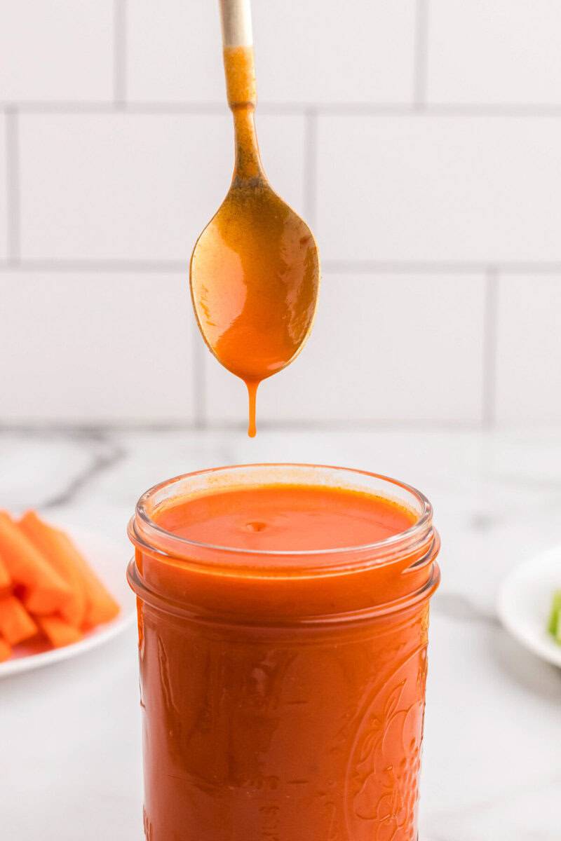 dripping the buffalo sauce off of a spoon.