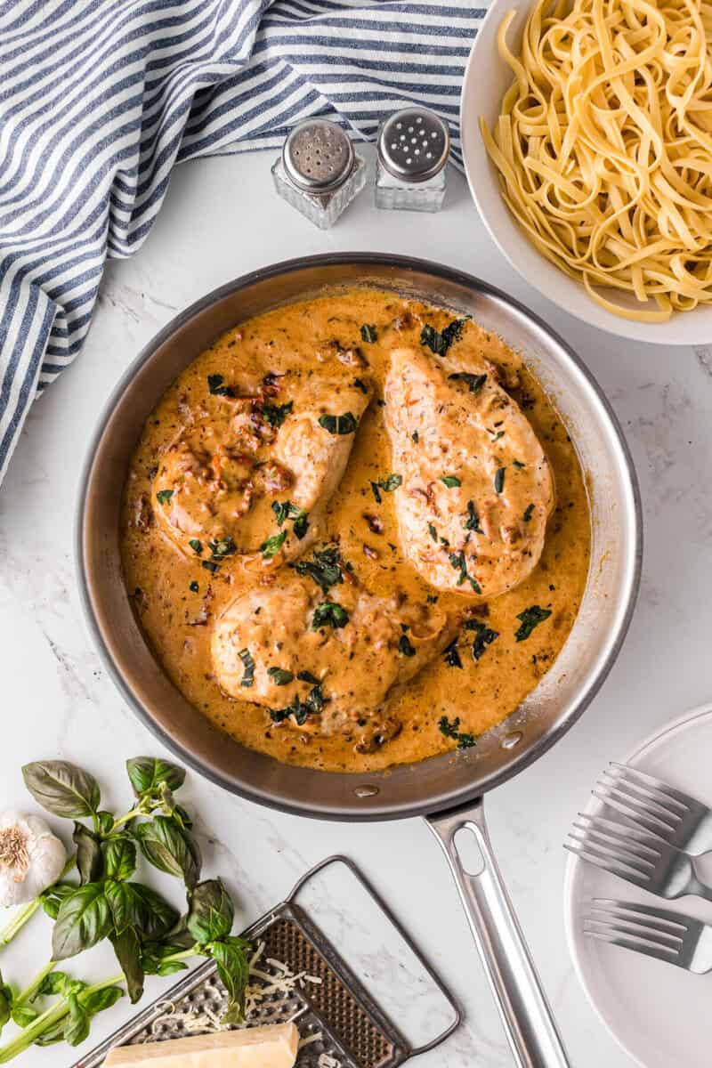cooking the chicken in the cream sauce.