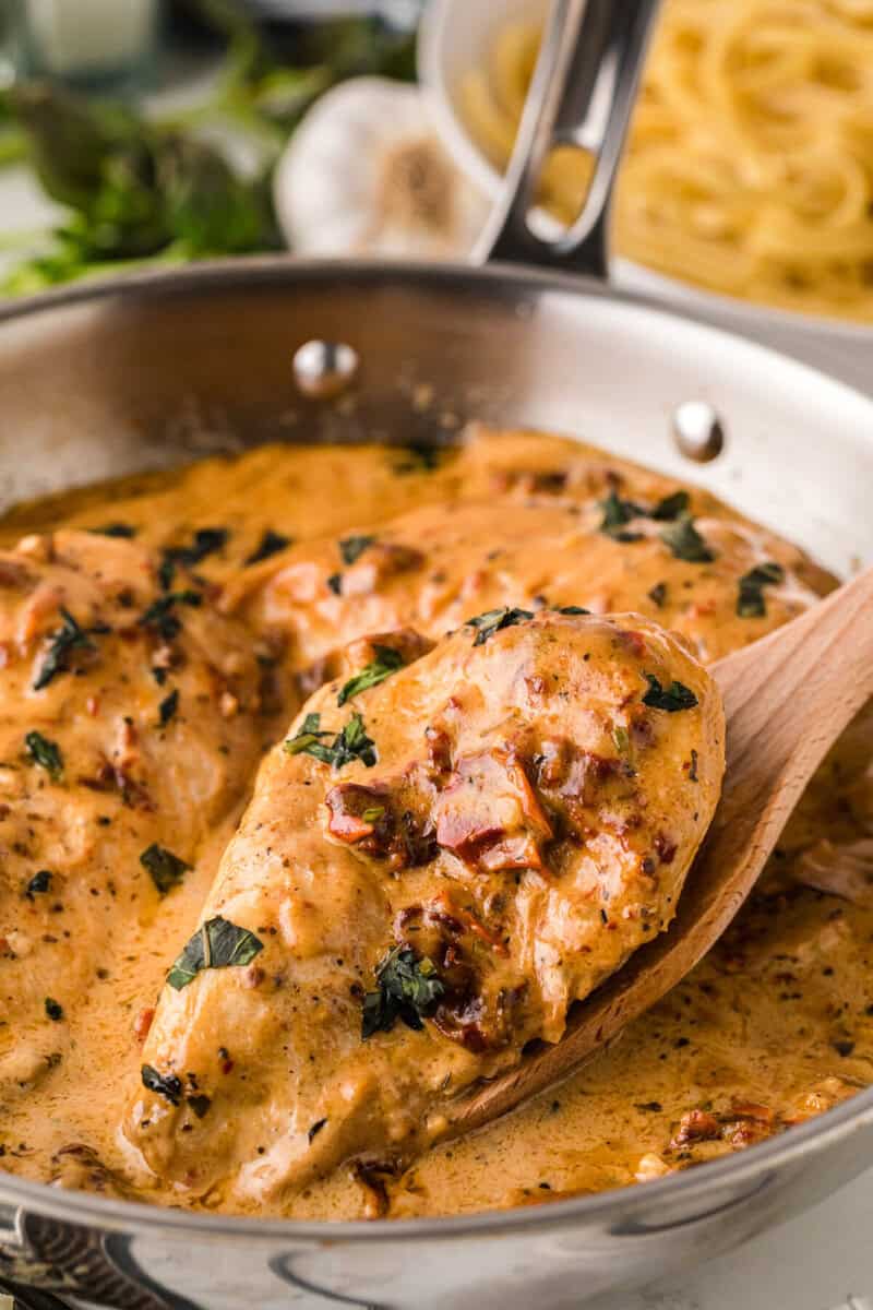 using a wooden spatula to serve the chicken.