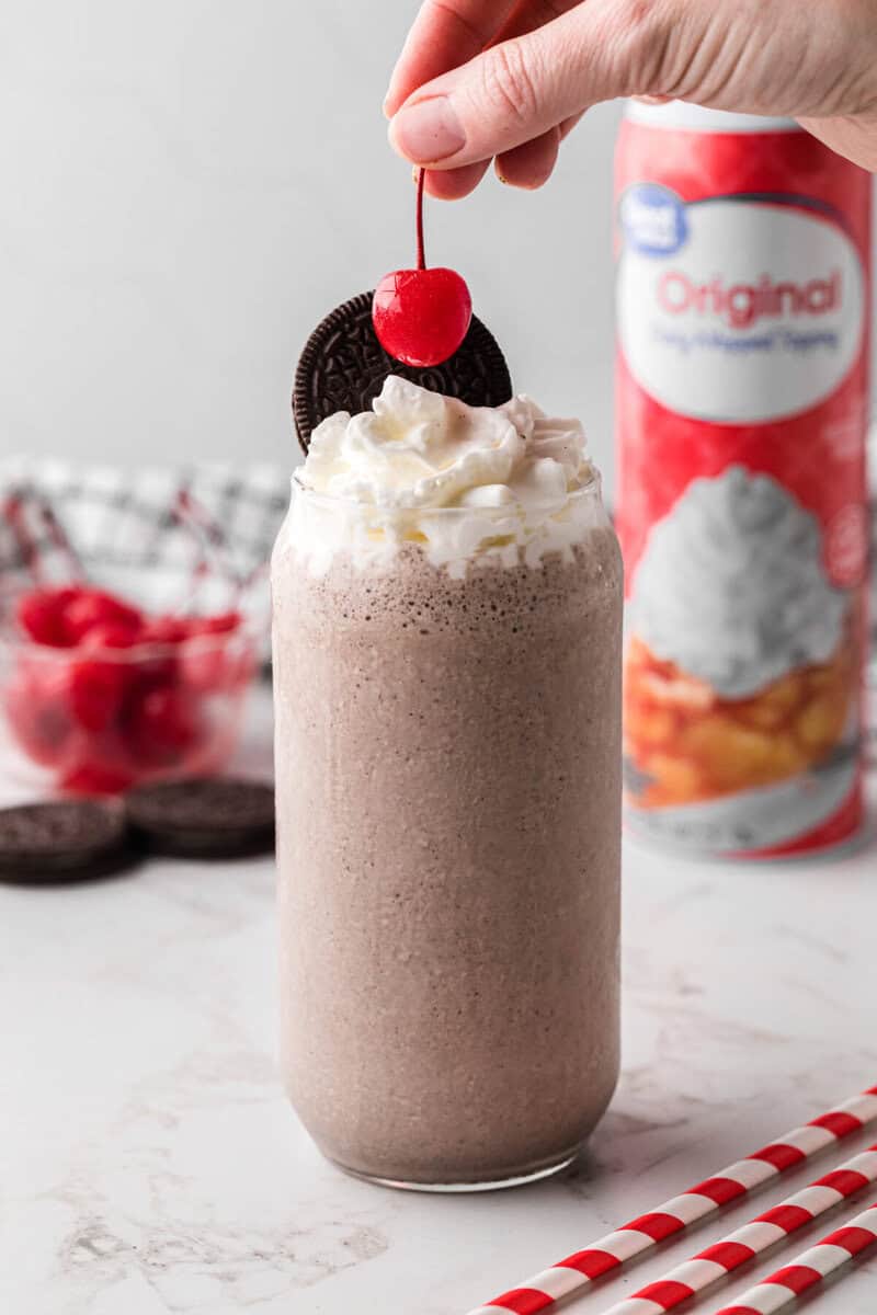 topping the milkshake with a cherry.