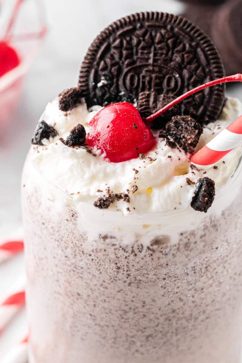 closeup of the Oreo Milkshake topped with whipped cream, cherry and another Oreo.
