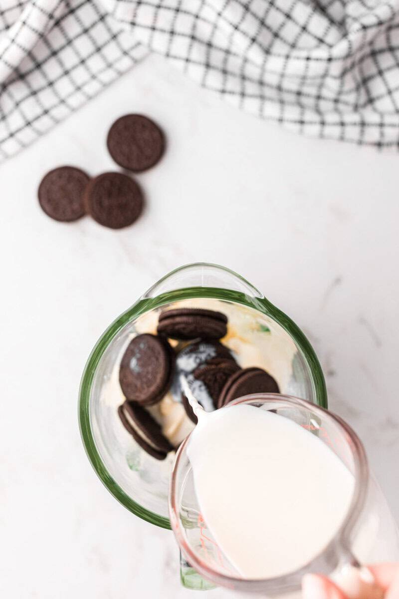pouring the milk into the blender for the milkshake.