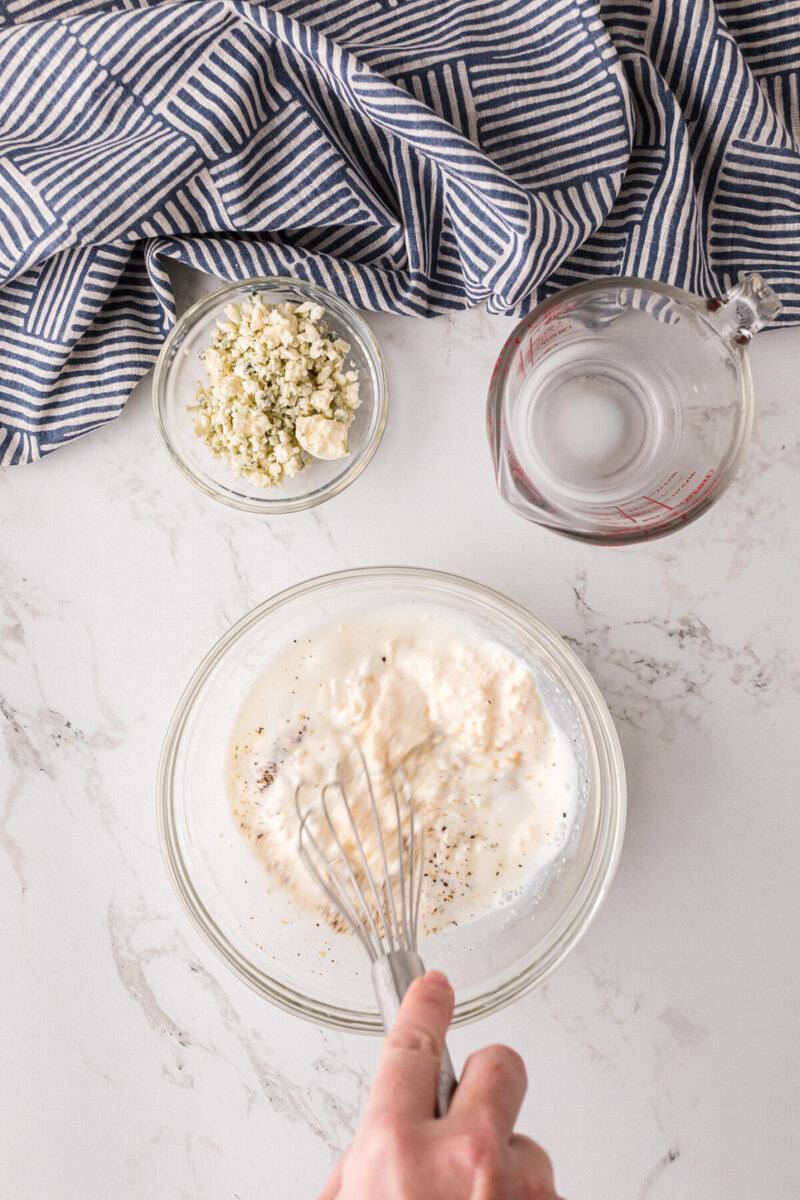 whisking together the ingredients for the homemade Blue Cheese dressing.