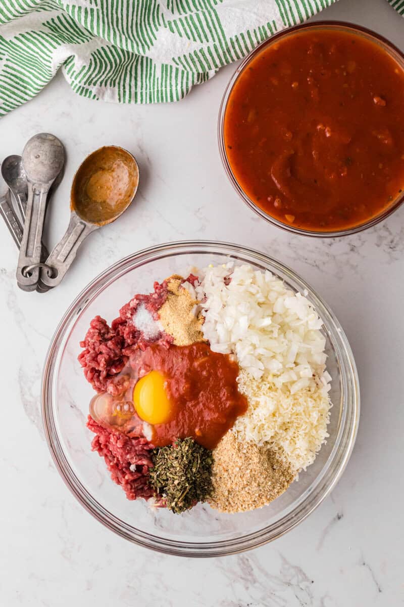 ingredients for the meatballs in a large glass mixing bowl.