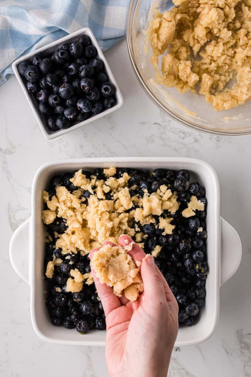 putting the topping on top of the blueberries.