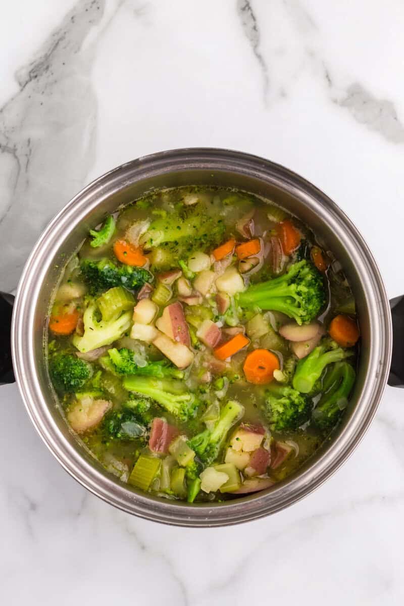 adding the broccoli to the soup.