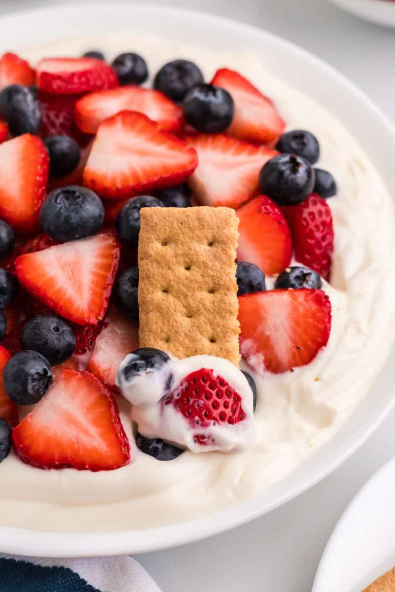 using a graham cracker to eat the dip.