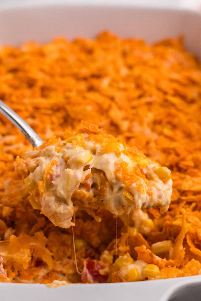 serving the Doritos Chicken Casserole with a metal spoon.