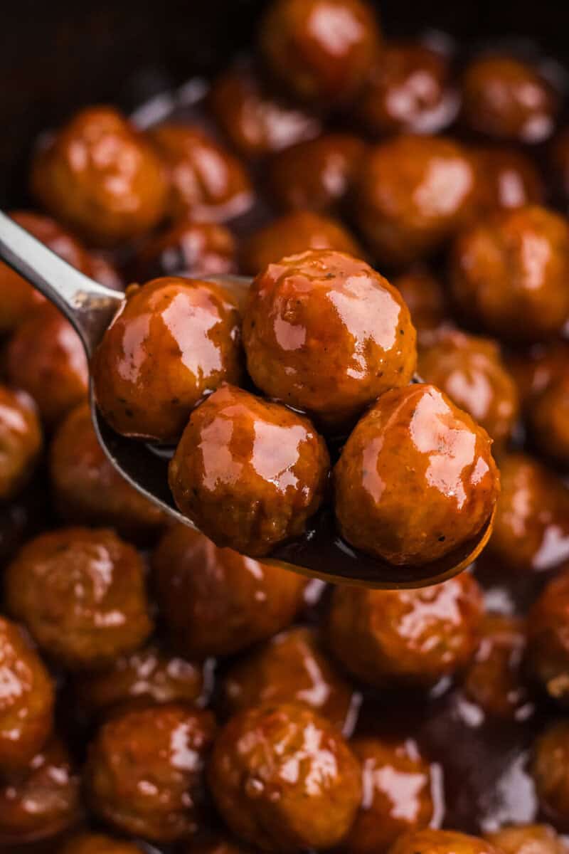 closeup of serving the meatballs with a metal spoon.