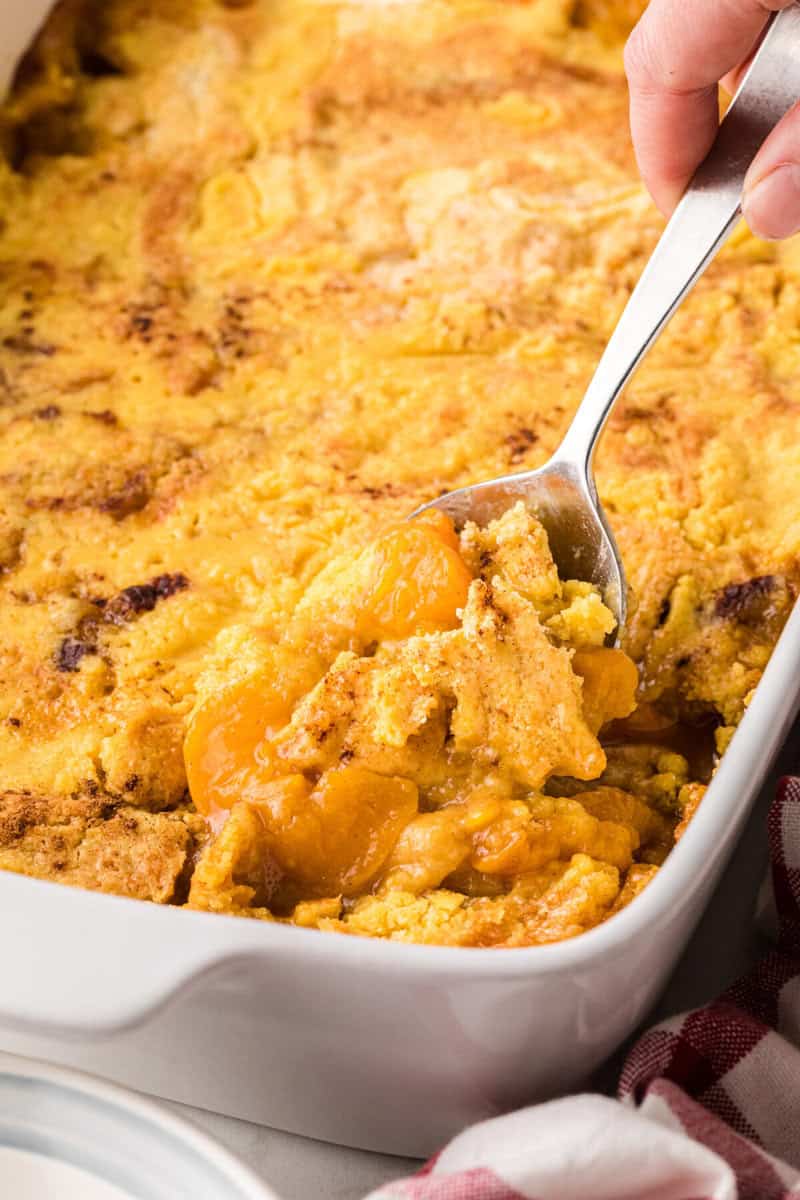 serving the Peach Dump Cake with a metal spoon.