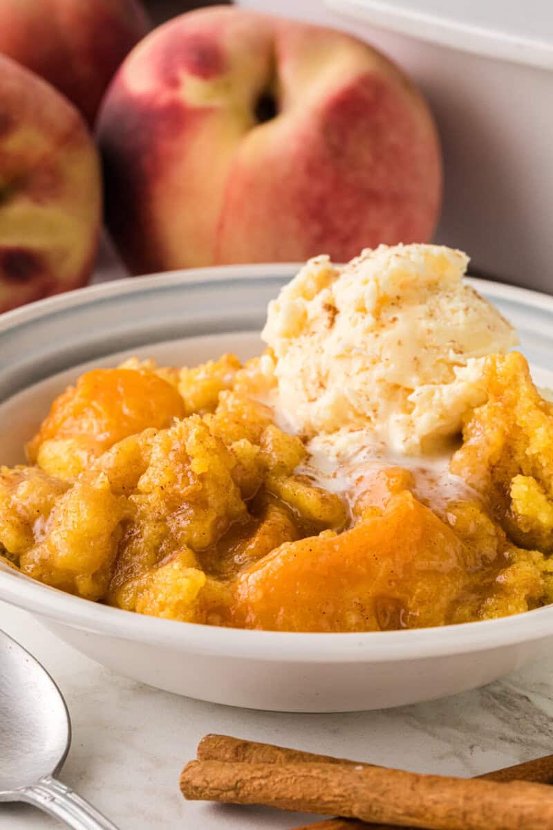 closeup of the Peach Dump Cake served in a white bowl.