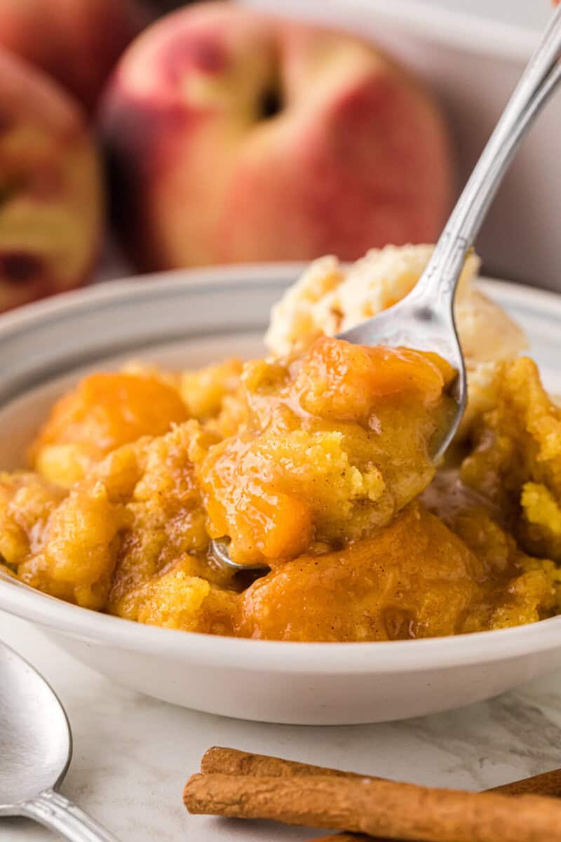 scooping the Peach Dump Cake with a metal spoon.