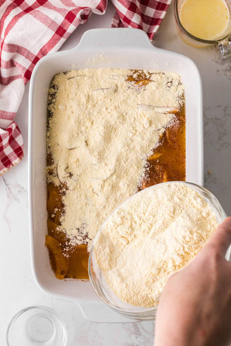 sprinkling cake mix on top of the peaches.