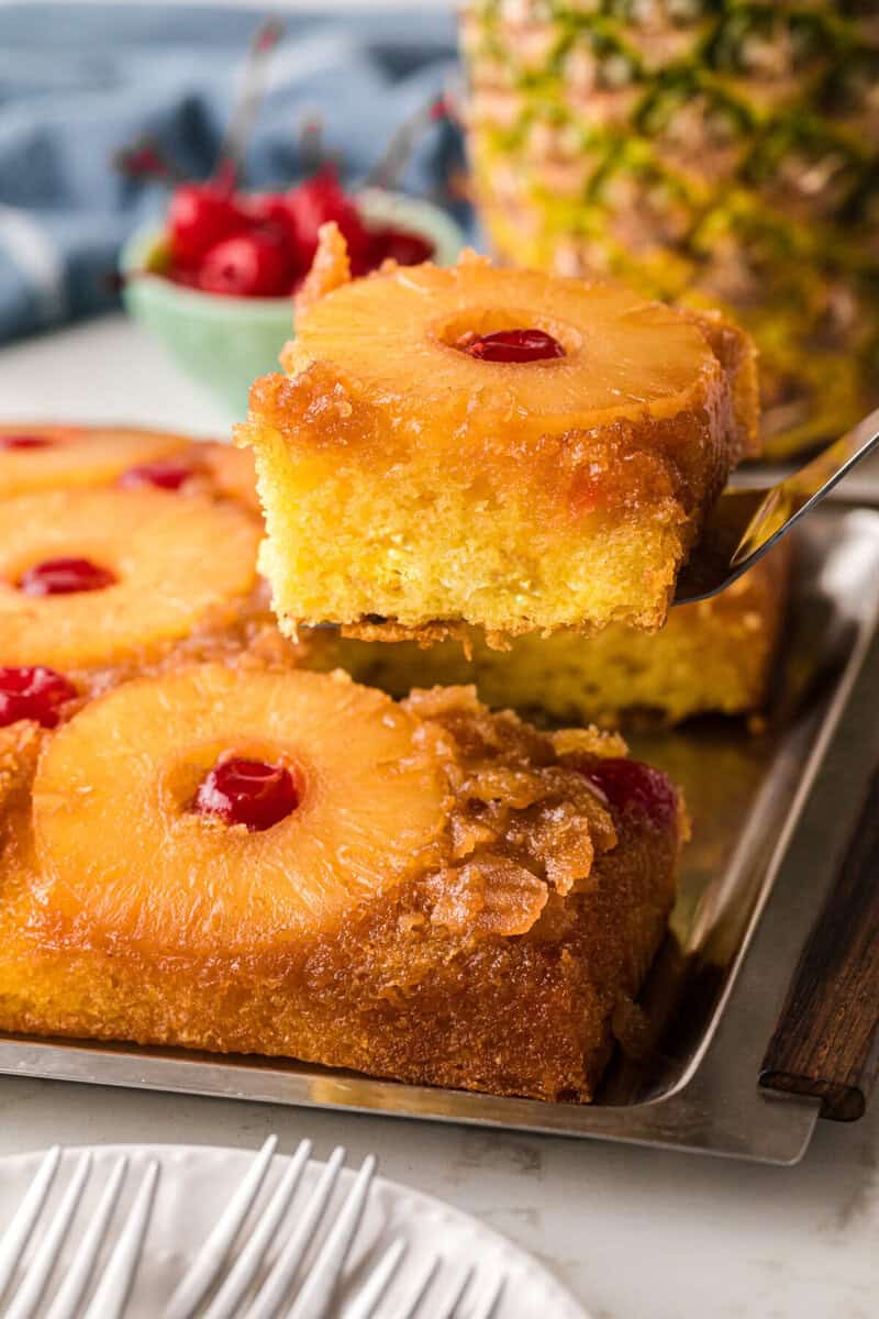 serving a slice of the pineapple upside down cake.