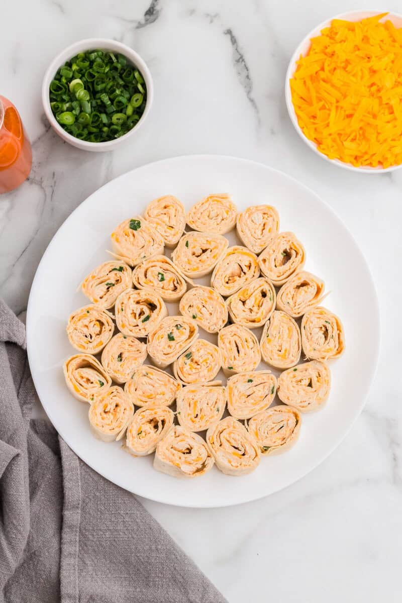 Buffalo Chicken Pinwheels sliced on a white serving plate.