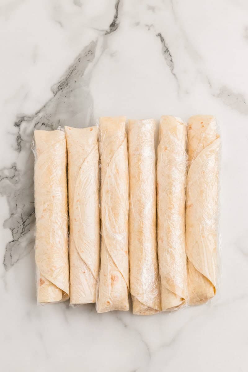 buffalo chicken wraps wrapped in plastic wrap.