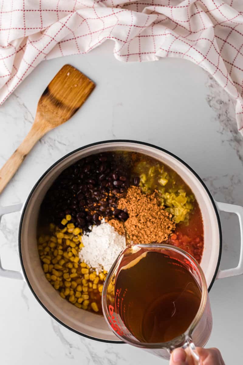 adding the beef broth to the soup.