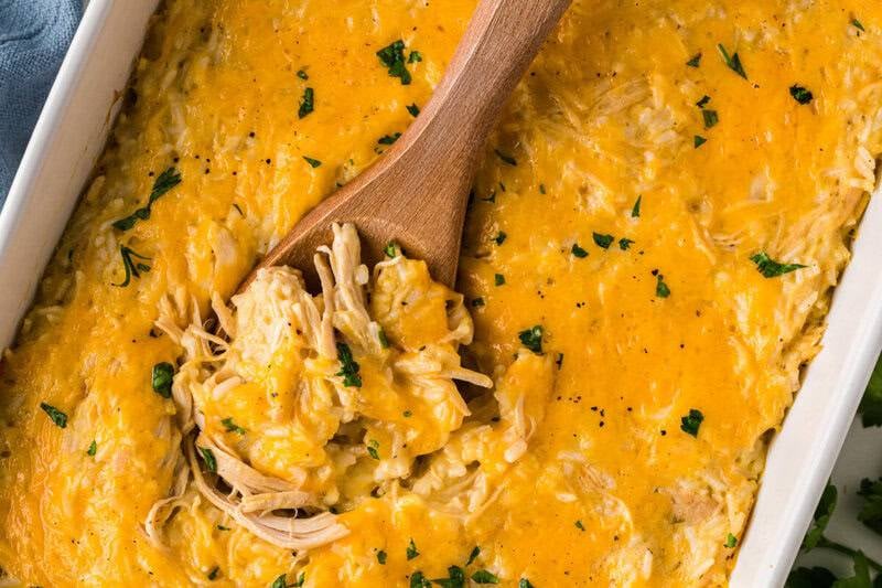 baked chicken and rice casserole topped with melted cheddar cheese in a 9x13 baking dish
