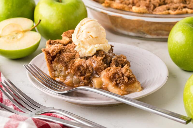 closeup of a slice of the Dutch Apple Pie served on a white plate.