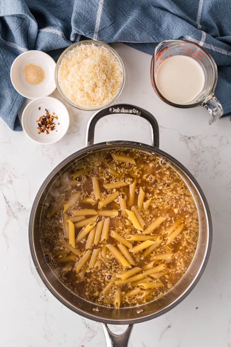 cooking the pasta in the chicken broth.