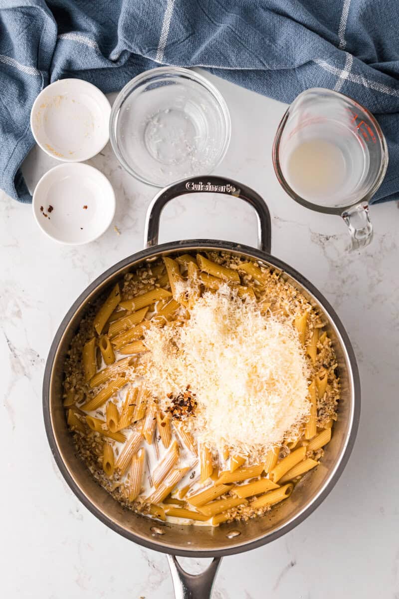 adding the heavy cream and parmesan cheese to the pasta.
