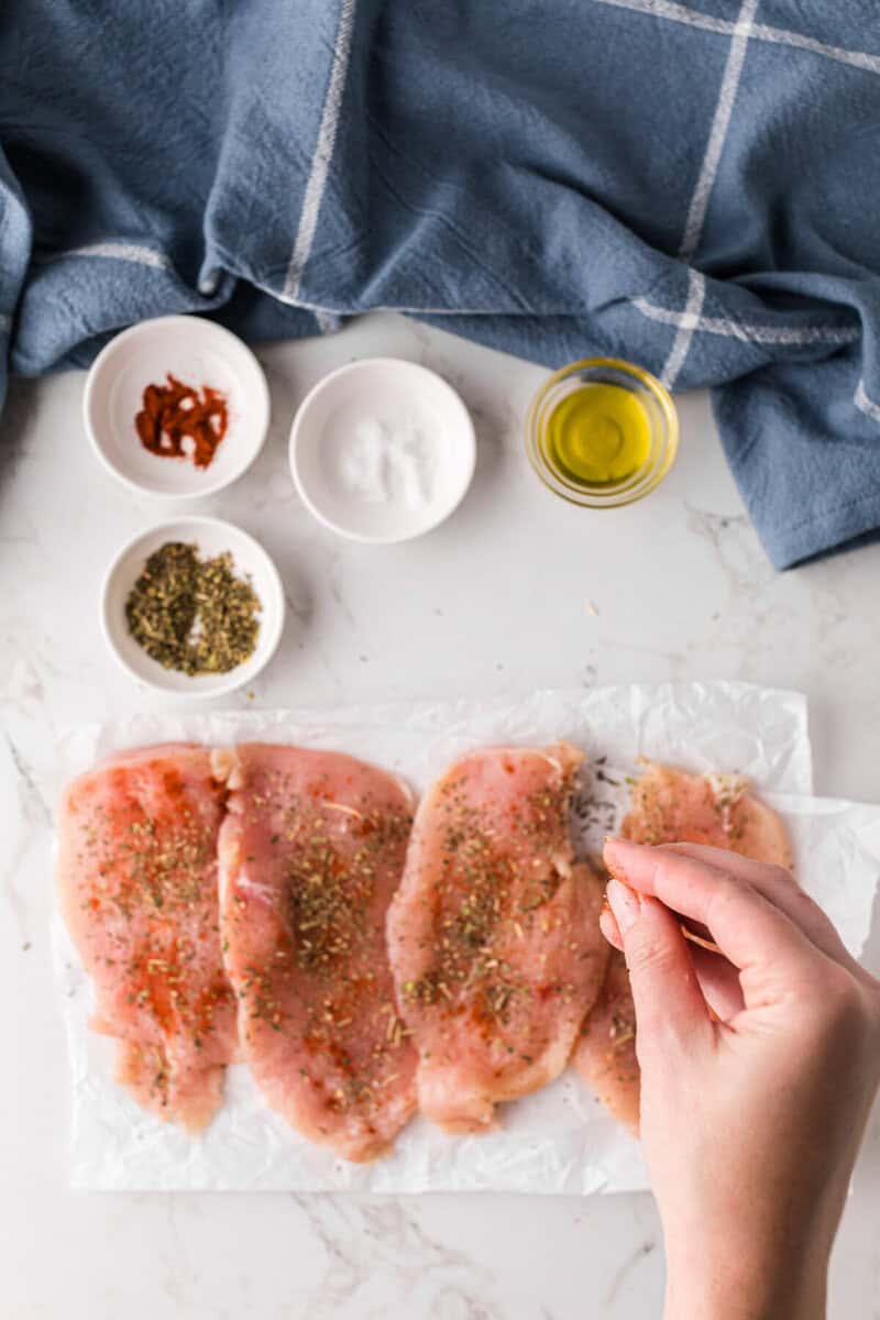 seasoning the chicken breasts.