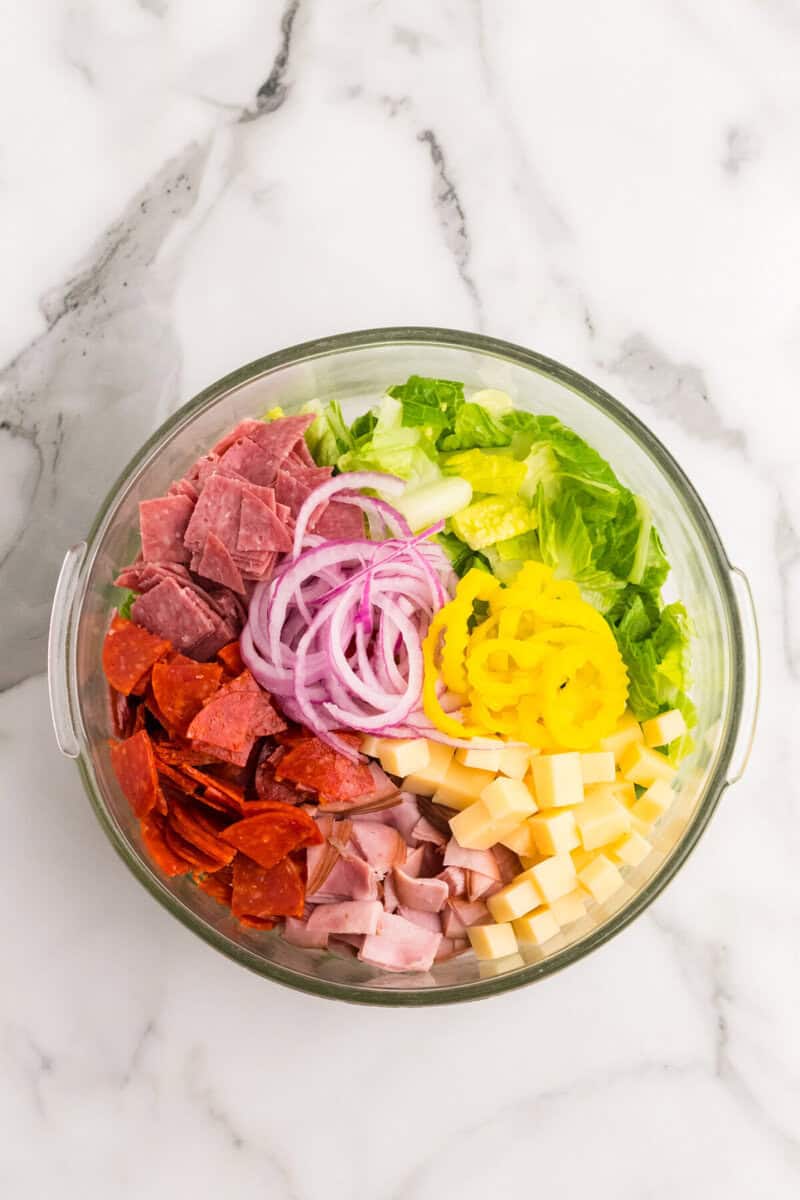salad ingredients in a large clear mixing bowl.