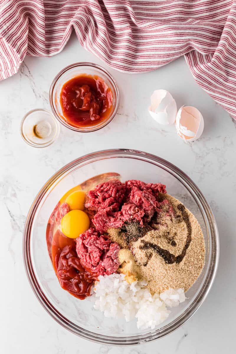 ingredients for the meatloaf in a glass mixing bowl.