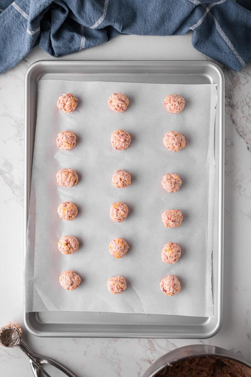 sausage balls rolled on a baking sheet.