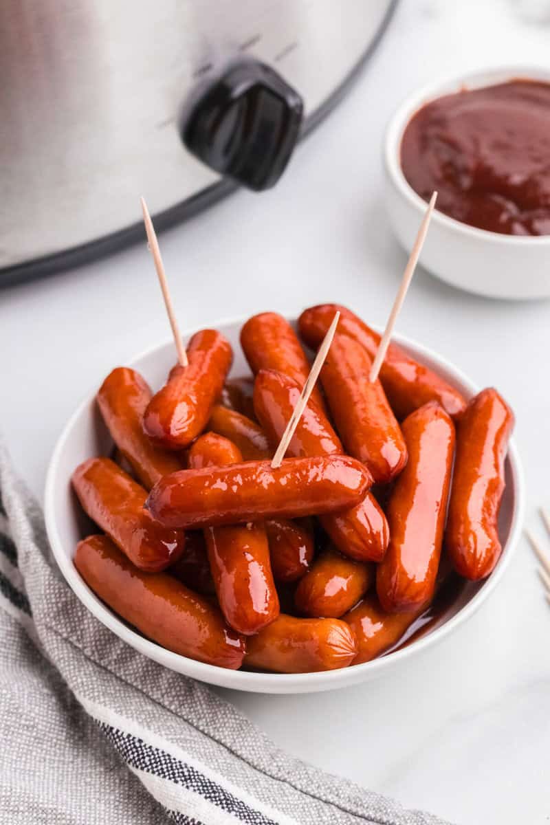 Little Smokies in a white bowl served with toothpicks.