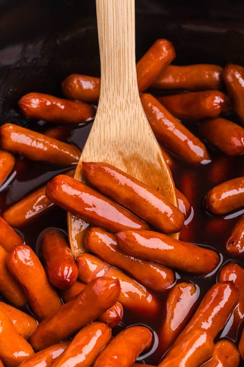 using a wooden spoon to serve the Little Smokies.