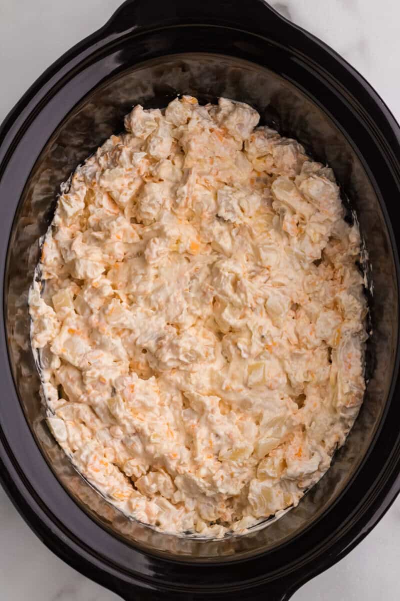 cheesy potato casserole mixed together in the slow cooker before cooking.