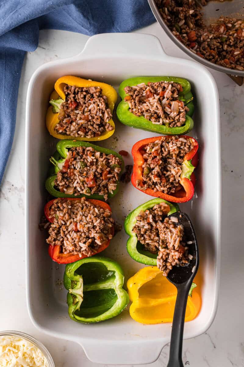 filling the peppers with the meat and rice filling.