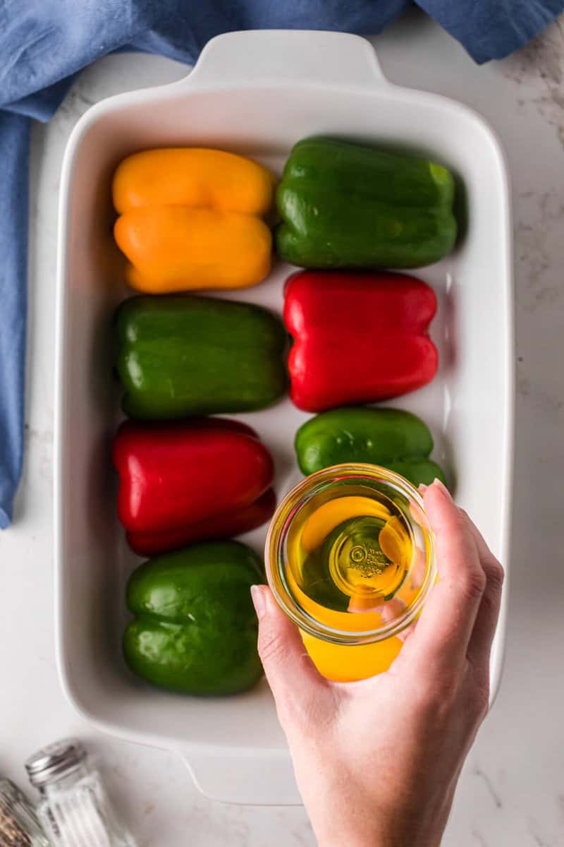 pouring oil over the peppers to cook them to get them ready.
